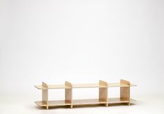 three wooden shelves sitting on top of each other in front of a white wall and floor