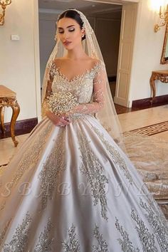 a woman in a wedding dress standing next to a mirror wearing a tiara and veil