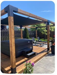 a hot tub sitting on top of a wooden deck next to a flower potted plant