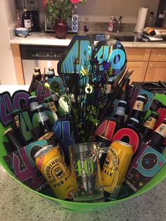 a green bowl filled with lots of different types of beer and liquor bottles on top of a counter