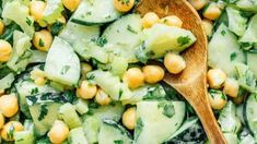 cucumber and chickpea salad with a wooden spoon in the bowl, ready to be eaten