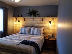 a bed sitting in a bedroom next to a window with two lights on each side