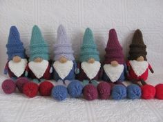 small crocheted gnomes lined up on a white surface