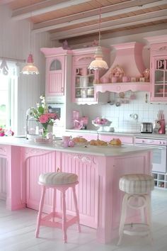 a pink kitchen with two stools in it