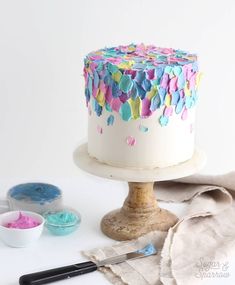 a white cake with colorful confetti on top and icing next to it