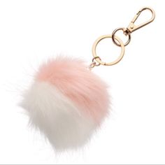 a pink and white pom - pom keychain on a gold chain