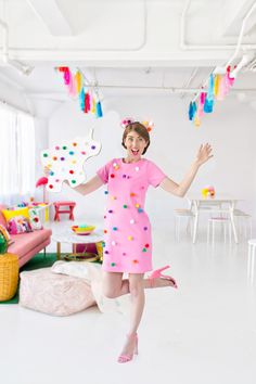 a woman in a pink dress is posing for the camera with her arms out and legs spread wide