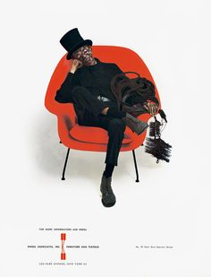 a man sitting in an orange chair with a black top hat on his head and legs