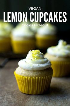 cupcakes with white frosting and yellow sprinkles sitting on a table