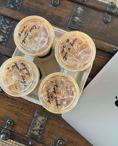 four glass coasters with writing on them sitting in front of an apple laptop computer