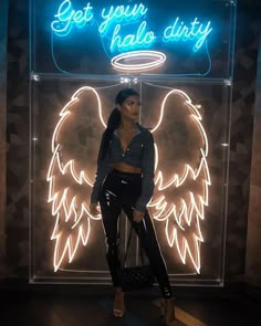 a woman standing in front of a neon sign