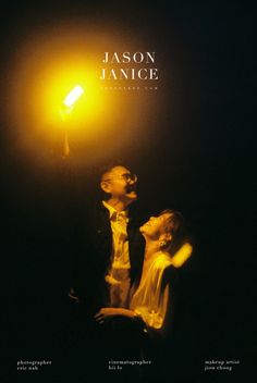 a man and woman standing next to each other under a street light in the dark