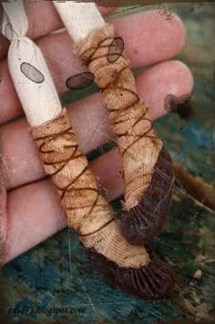 a hand is holding two small wooden beads