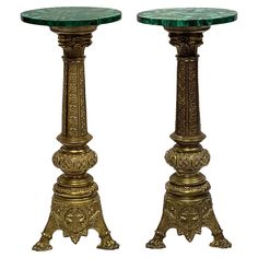 two golden pedestals with green marble tops