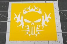 a yellow square with a white skull and flames on it in the middle of a tiled floor