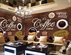 a coffee shop with couches and chairs in front of a brick wall that has coffee cups painted on it