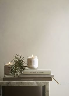 two candles sitting on top of a stack of books