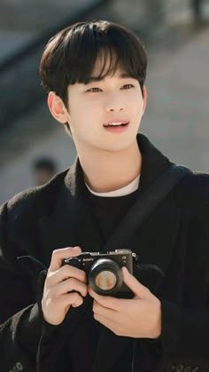 a young man holding a camera in his hands