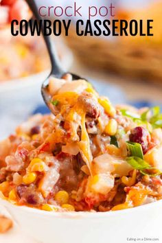 a spoon full of cheesy casserole being lifted from a white bowl