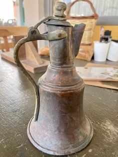 an old coffee pot sitting on top of a wooden table