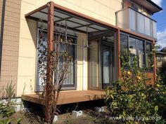 a house that is made out of wood and glass with an open porch on the outside