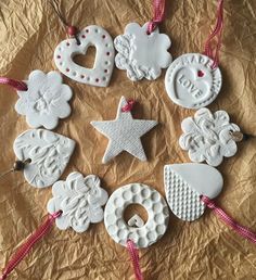 christmas ornaments are arranged in the shape of hearts, wreaths and stars on a piece of brown paper