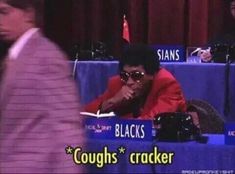 a man sitting at a table in front of a microphone with the words coughs cracker on it