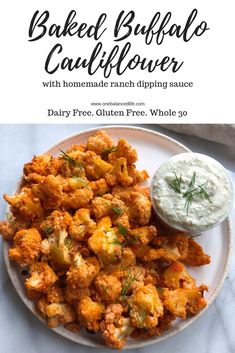 baked buffalo cauliflower with homemade ranch dipping sauce on a white plate and text overlay reads baked buffalo cauliflower with homemade ranch dipping sauce