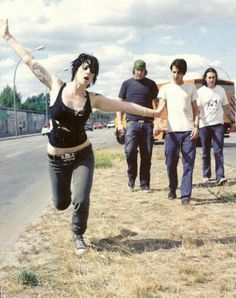 a group of people standing on the side of a road