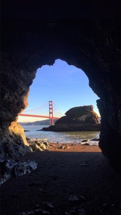 the golden gate bridge is seen through a cave