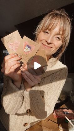 a woman is holding up some cards in her hands with the words love on them