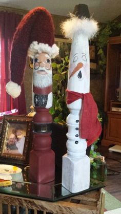 two snowmen are standing next to each other in front of a christmas decoration on a coffee table