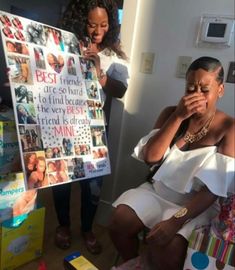 a woman sitting on a chair in front of a sign with pictures and people around her