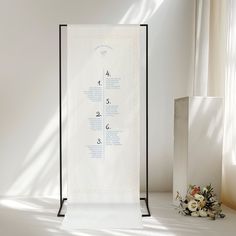 a wedding ceremony program displayed in front of a white backdrop with flowers on the side