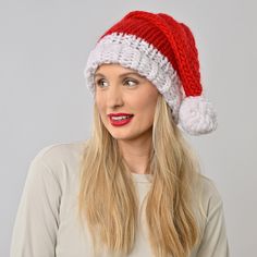 a woman wearing a red and white knitted santa hat