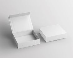 an open white box sitting on top of a table next to a smaller empty box