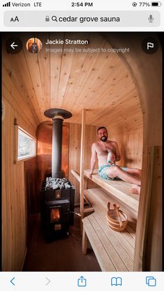 a man sitting in a wooden sauna next to an open fire place