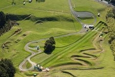 an aerial view of a winding road in the middle of a lush green field with lots of trees