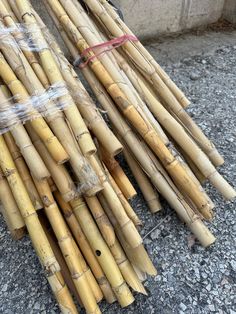 several bundles of bamboo sitting on the ground