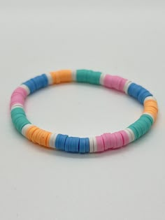 a bracelet with multi colored beads on a white surface