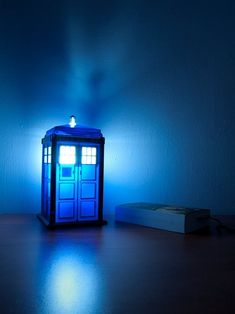 a blue tardish sitting on top of a wooden table next to a box