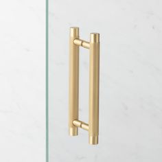 an image of a door handle on a white marble wall with gold colored metal handles