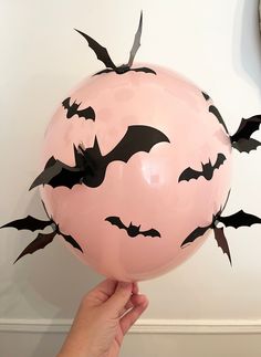 a person holding a balloon with bats on it