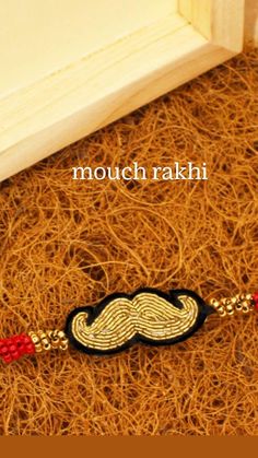 a red string bracelet with a black and gold moustache on it