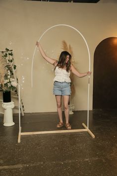 a woman standing in front of a white arch