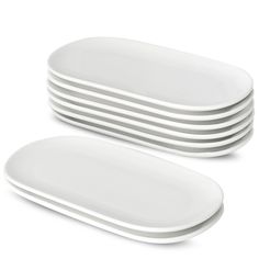 white plates stacked on top of each other in the shape of rectangles and oval shapes