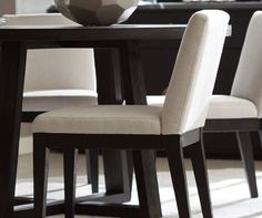 a dining room table with chairs and a vase on it