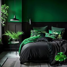 a bedroom with green walls and black bedding, plants on the nightstands in front of the bed