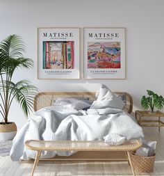 a white bedroom with two moon prints on the wall and a wicker bed frame