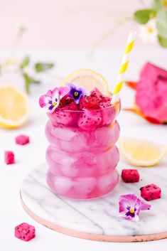 a pink drink with lemon slices and flowers in it